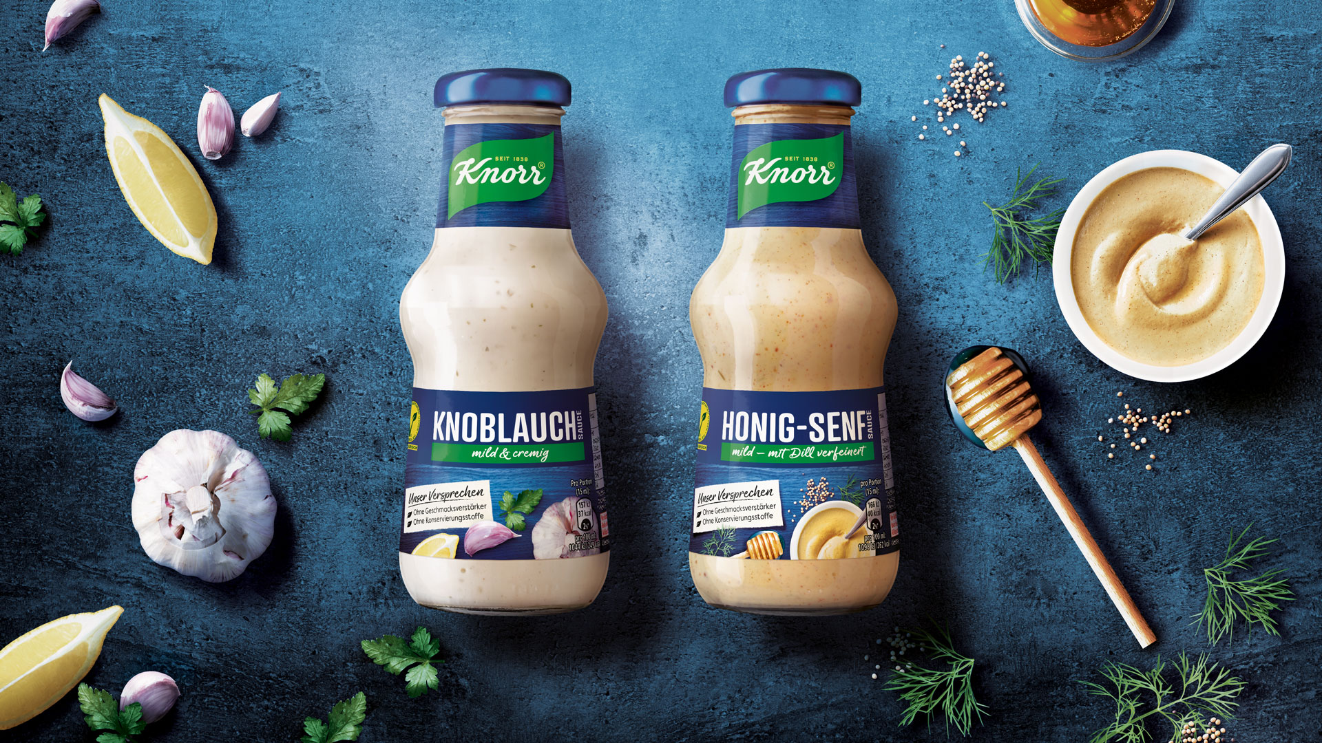 Unilever Knorr Grillsaucen Packshots auf blauem Untergrund eingebettet in Zutaten