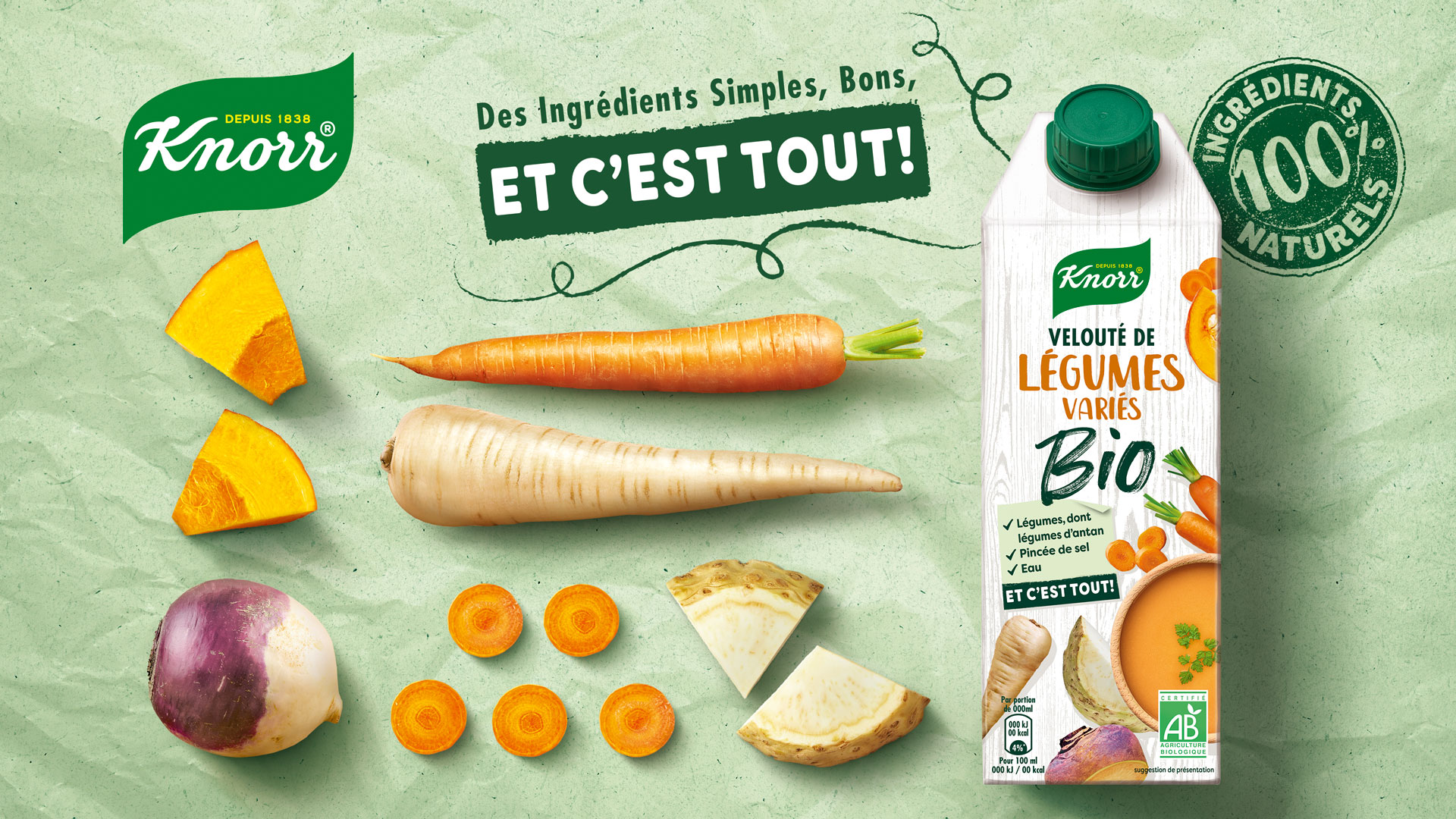 Unilever Knorr Velouté de Légumes Variés Bio Packshot auf grünem Papieruntergrund neben frischen Zutaten
