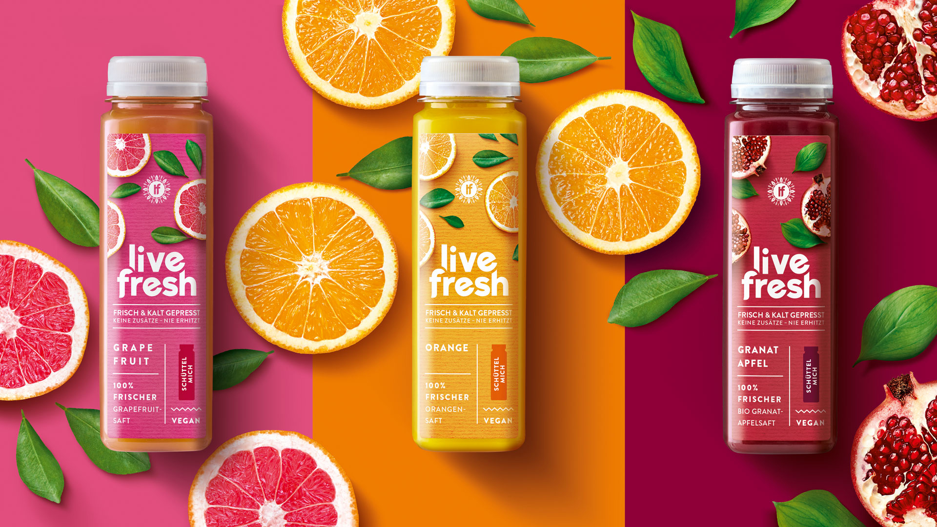Drei live fresh Saft Flaschen auf farbigem Untergrund umringt von Zutaten