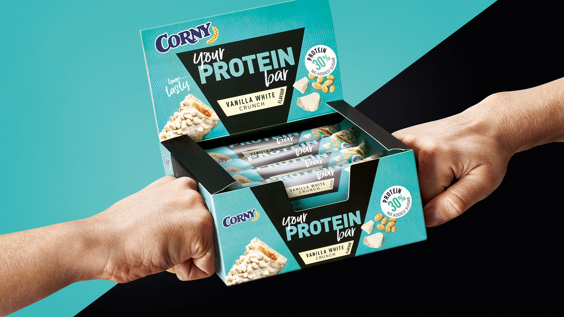 Zwei Fäuste halten einen Tray Corny Protein Bar Vanilla White Crunch