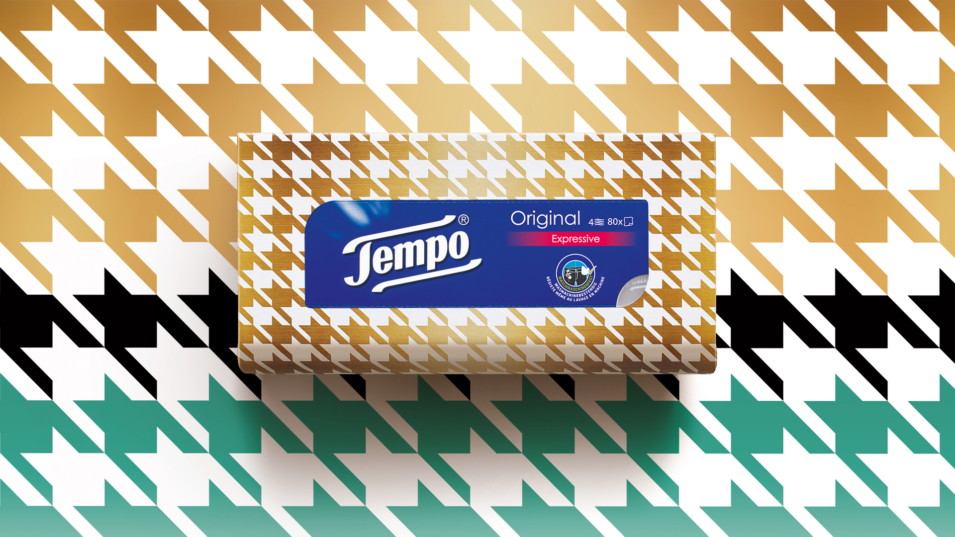 Tempo Original Taschentuchbox mit auffälligem Hahnentritt-Muster in Gold, Weiß, Schwarz und Türkis – harmonisch inszeniert vor einem nahtlos übergehenden Hintergrund im gleichen Design für einen modischen, expressiven Look