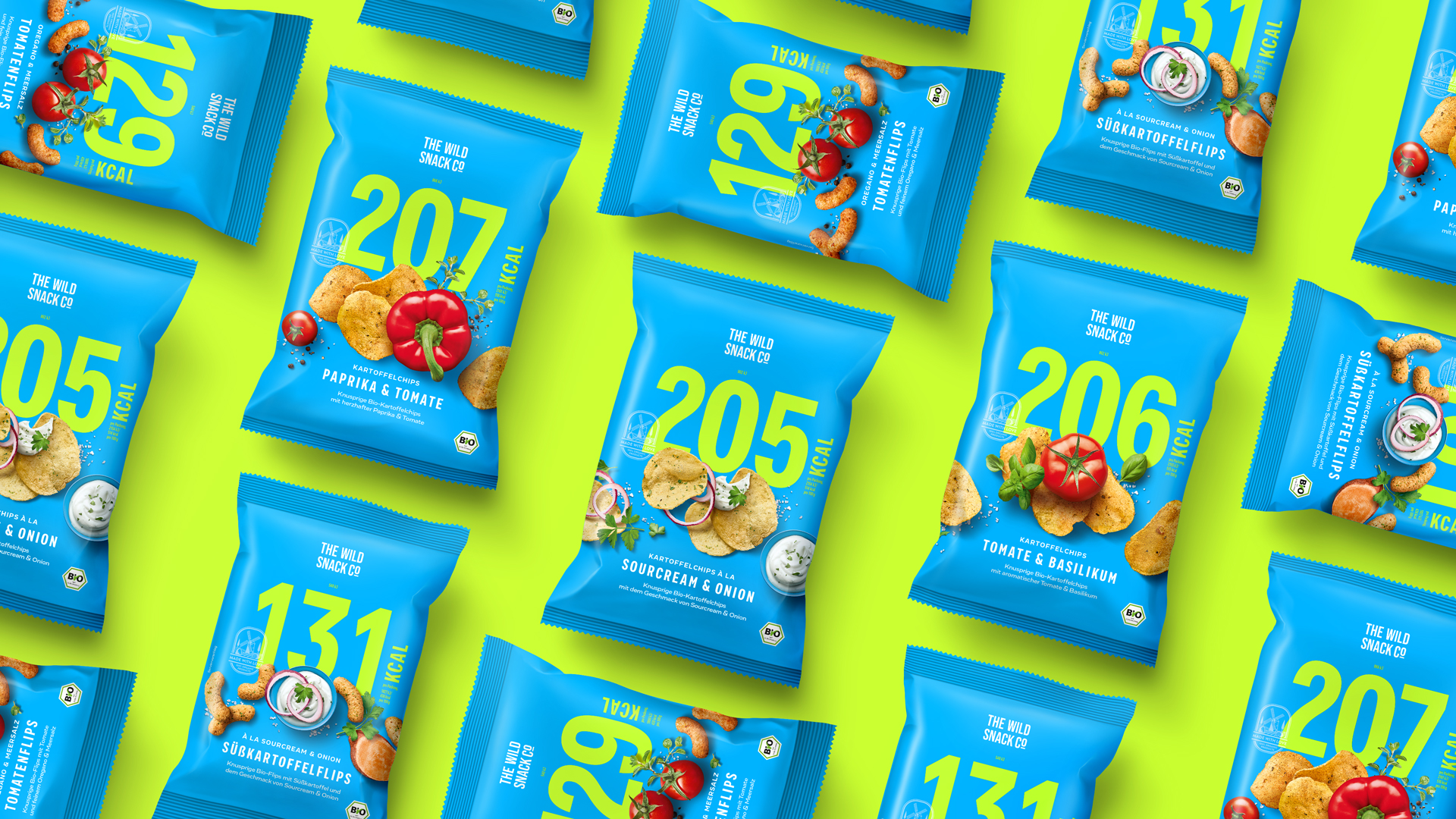 Dynamisches Flatlay von The Wild Snack Co Chips & Flips: Verschiedene Sorten wie Paprika & Tomate, Tomate & Basilikum oder Süßkartoffelflips mit Sourcream & Onion auf knallgrünem Hintergrund – auffälliges Verpackungsdesign in Cyanblau mit großflächiger Kalorienzahl und frischen Zutatenabbildungen.