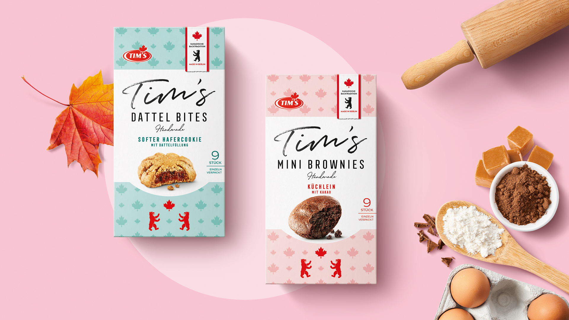 Charmantes Duo-Design für Tim’s Dattel Bites und Mini Brownies: Verpackungen in zartem Türkis und Rosa, inszeniert auf rosafarbenem Untergrund mit Ahornblatt, Backzutaten und stilvoller Food-Fotografie im Handmade-Look