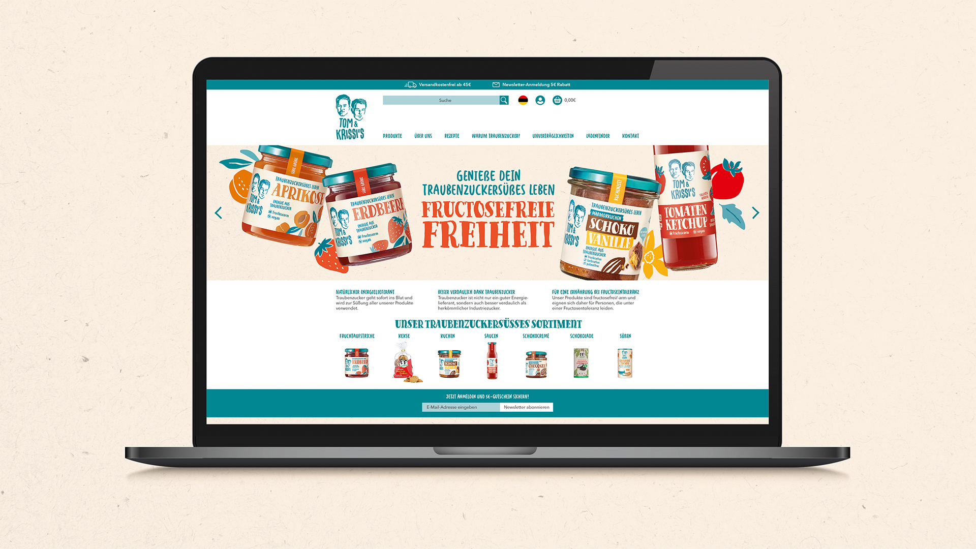 Desktop-Ansicht der Tom & Krissi’s Website auf einem Laptop: Startseite mit auffälligem Markenbanner, fruchtzuckersüßem Sortiment, handgezeichneten Produktillustrationen und dem Claim ‚Genieße dein Traubenzuckersüßes Leben – fructosefreie Freiheit‘ im verspielten Retro-Look.