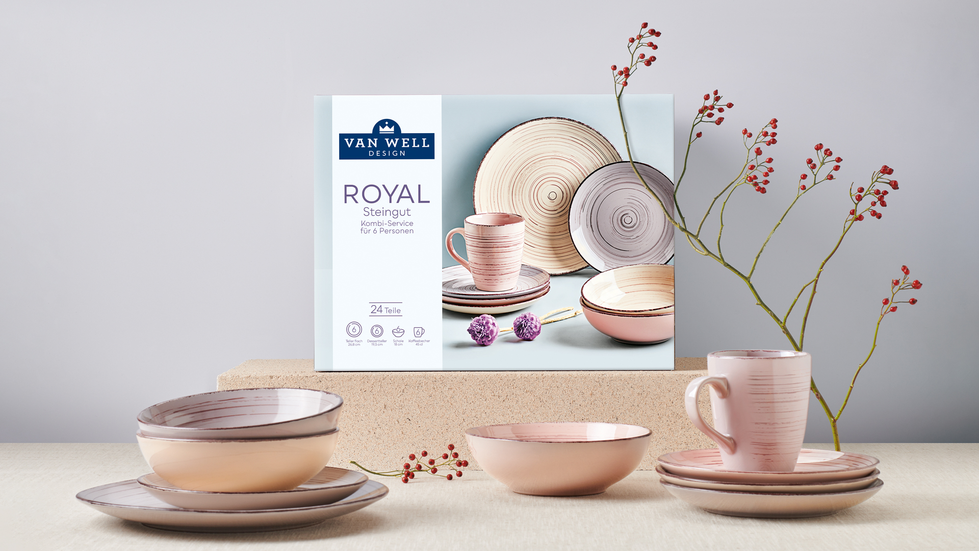 Elegante Produktinszenierung des Van Well Design Kombi-Services ‚ROYAL‘ aus Steingut: Verpackung mit Servicemotiv und stilvoll arrangiertem Geschirr in zarten Rosé- und Naturtönen – präsentiert mit Trockenblumen und neutralem Hintergrund für ein modernes Wohnambiente.